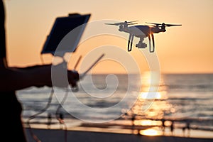 Drone operated by young man flying over an sea