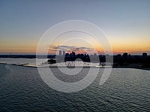 Drone over harbor with cityscape at seaside in Wisconsin at sunset