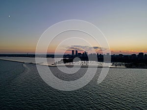 Drone over harbor with cityscape at seaside in Wisconsin at sunset