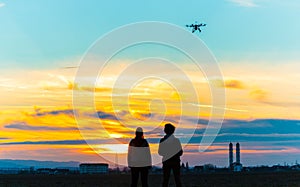Drone over the Village at cloudy Sunset with his Pilot