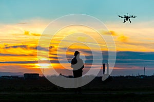 Drone over the Village at cloudy Sunset with his Pilot