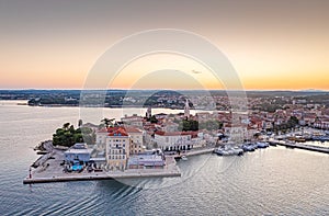 Drone panorama of Croatian coastal town Porec with harbor and promenade during sunrise
