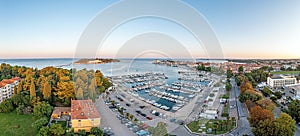 Drone panorama of Croatian coastal town Porec with harbor and promenade during sunrise