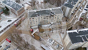 Drone photography of aftermath multistory residential building fire and emergency service cleaning up during winter day