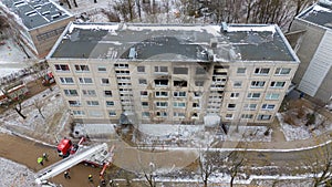 Drone photography of aftermath multistory residential building fire and emergency service cleaning up during winter day