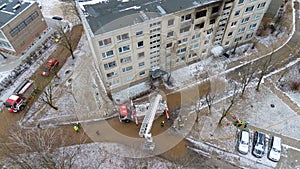 Drone photography of aftermath multistory residential building fire and emergency service cleaning up during winter day