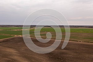 Drone photography of agricultural equipment working in field and spreading fertilizer