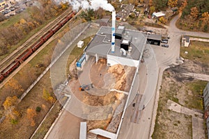 Drone photography of biomass power plant and biomass storage place during autumn day