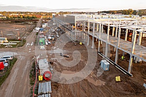 Drone photography of constructions site of large commercial building with construction machinery and construction workers during