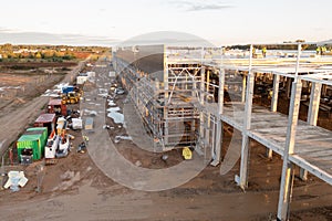 Drone photography of constructions site of large commercial building with construction machinery and construction workers during