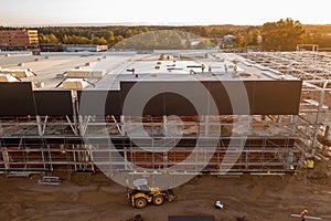 Drone photography of constructions site of large commercial building with construction machinery and construction workers during