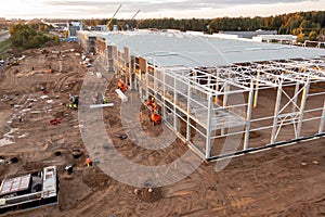 Drone photography of constructions site of large commercial building with construction machinery and construction workers during