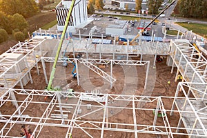 Drone photography of constructions site of large commercial building with construction machinery and construction workers during