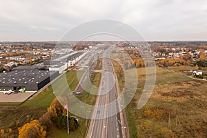 Drone photography of highway going out of city during autumn day