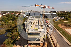 Drone photography of new office building construction site, cranes and construction workers