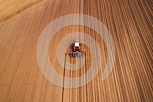 Drone photography of tractor with seeder working in field