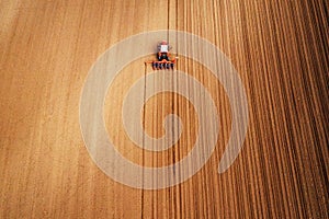 Drone photography of tractor with seeder working in field