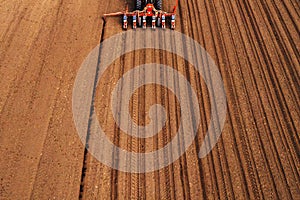 Drone photography of tractor with seeder working in field