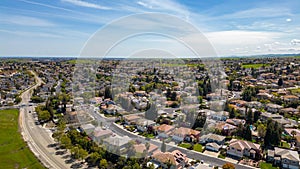 Drone photos over the city of Antioch, California on a beautiful sunny day with green hills, streets, houses, cars and solar
