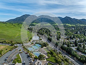 Drone photos over the Oakhurst neighborhood in Clayton, California with green hills, golf course and homes