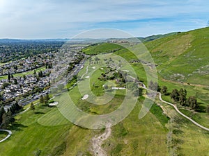 Drone photos over the Oakhurst neighborhood in Clayton, California with green hills, golf course and homes