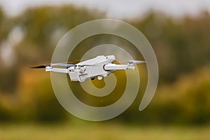 Drone with propeller, battery and camera flying over a meadow
