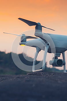 Drone quad copter with digital camera at sunset ready to fly for