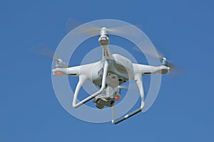 Drone quad copter with high resolution digital camera on the sky . White drone with digital camera flying in sky over mountain Dro