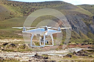 Drone quad copter with high resolution digital camera on the sky .White drone with digital camera flying in sky over mountain Dron