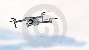 Drone quadcopter with digital camera in flight on sky