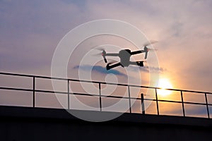 Drone quadcopter flying at sunset