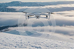 drone quadcopter in snowy mountains and clouds