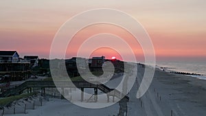 Drone rising up to see the sun rising over Fire Island New Yorks beach and ocean