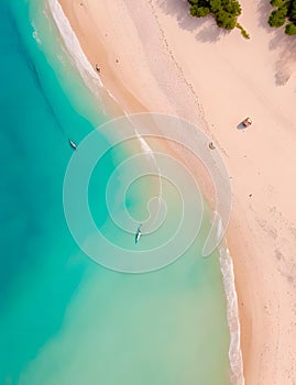 A drone\'s eye view of a pristine beach, with crystal clear waters and white sand stretching as far as the eye can see.