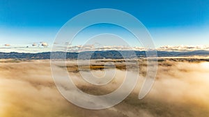 Drone scene of low cloud in the valley with the mountain range above the clouds
