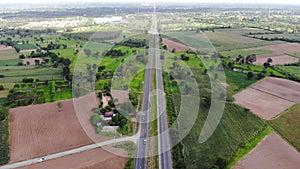 Drone shot aerial view scenic landscape of countryside rural highway traffic with fresh green and nature plant in the road side