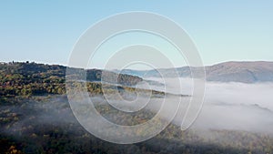 Drone shot, aerial view of Umbria, Tuscany in Italy. Sunrise with fog in early morning. Clouds in the valley.