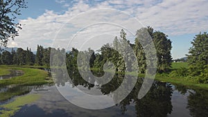 Drone shot along a beautiful still slough showing a perfect reflection