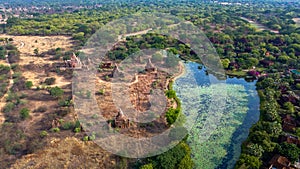 Drone Shot of Bagans magical Pagodas next to Hotels in Myanmar, seperated by a beautiful Lake.