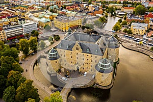Drone shot of the beautiful Orebro Castle surrounded with Svartan river and the cityscape of Sweden
