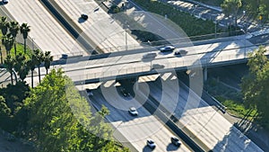 Drone shot of busy motorway with multilane roads surrounded with lush greenery