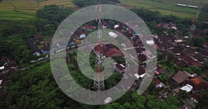 Drone shot of Cellular antenna in the middle of tropical village in the morning