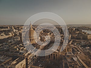 Drone shot of the cityscape of the Capital city of Malta, Valleta at sunrise by the water