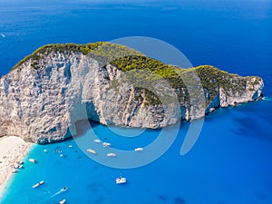 Drone shot of the famous Navagio beach and high limestone walls surrounding the shipwreck at the beautiful turquoise Ionian sea,