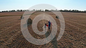 Drone shot of father and son running across field