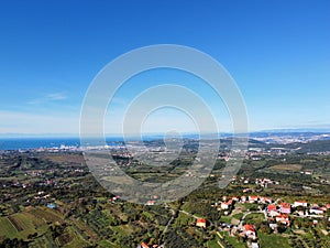 Drone shot of houses in Capodistria city on the green Luka Koper harbor in Slovenia