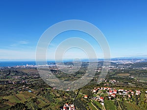 Drone shot of houses in Capodistria city on the green Luka Koper harbor in Slovenia