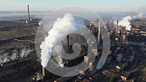 Drone shot of industrial zone with thick smog and burning fossil fuels.