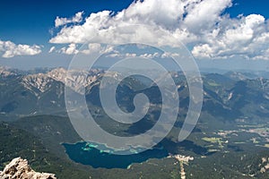 Drone shot of a lake in mountain landscape under blue cloudy sky