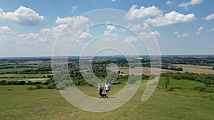 Drone shot of mature couple walking with pet dog through beautiful English countryside